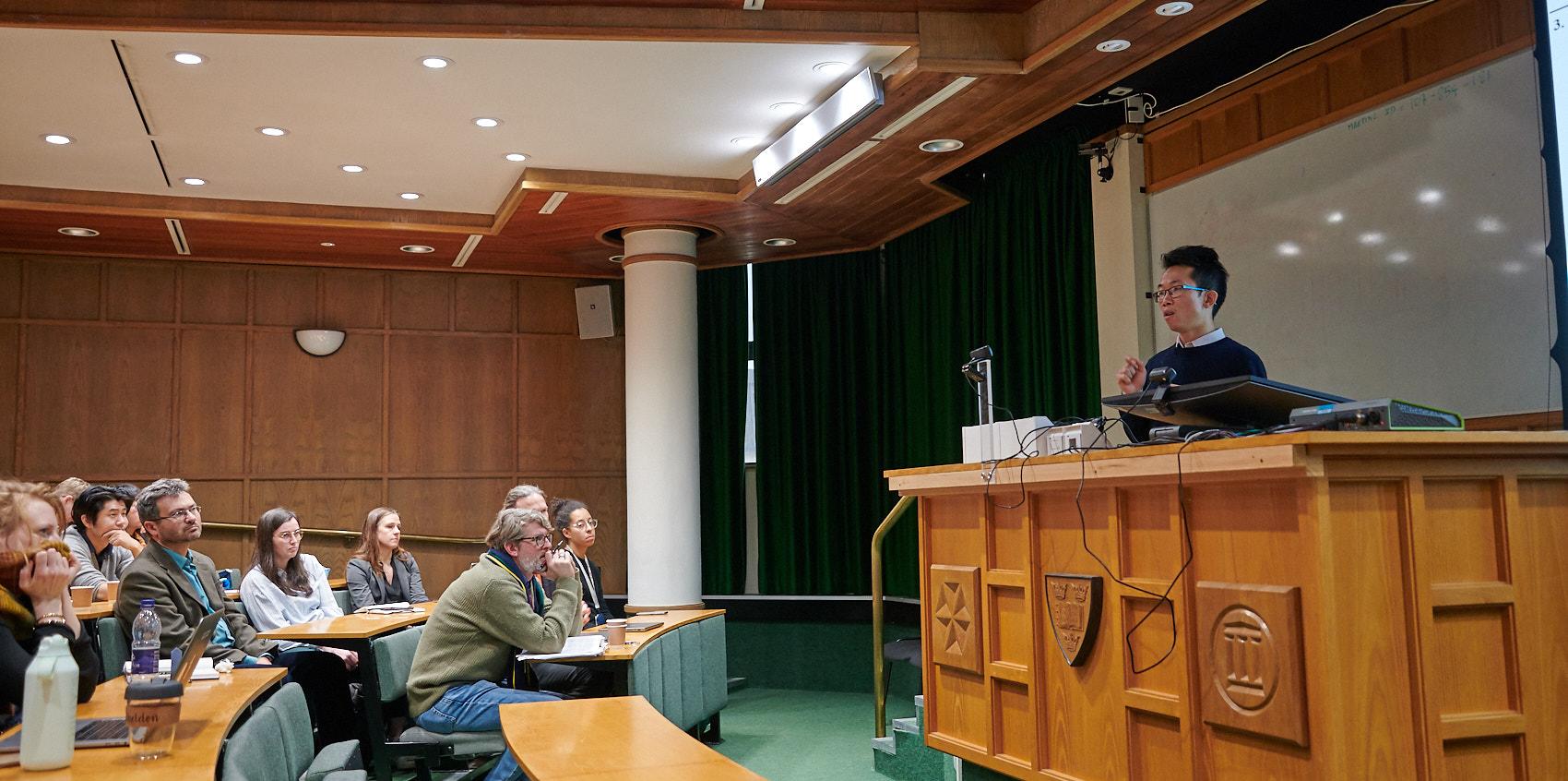 A photo of Shenghong He presenting his research to Unit colleagues at Winter Science Day 2023.