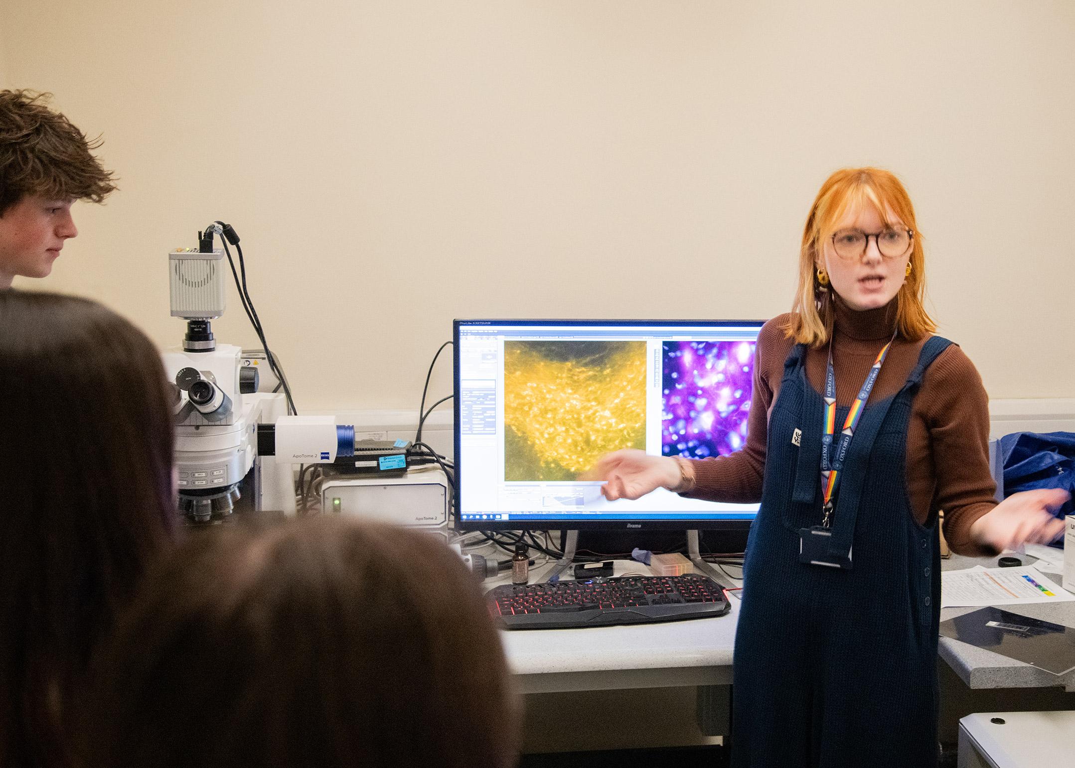 Photo of MRC BNDU researcher Jennifer Blackmore standing next to the confocal microscope.